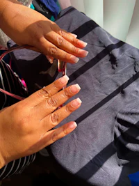 a woman is cutting her nails with a pair of scissors