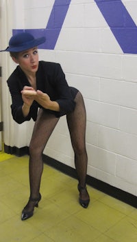 a woman wearing a hat and black pants
