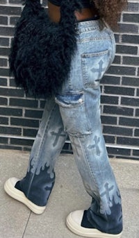 a woman wearing jeans and a black purse