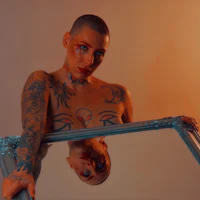 a woman with tattoos holding a mirror