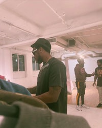 a group of men standing in a room looking at clothes