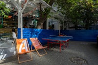a ping pong table and chairs in a courtyard