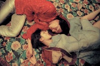 a man and a woman laying on a floral bed