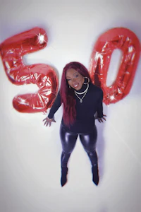 a woman posing in front of balloons with the number 50