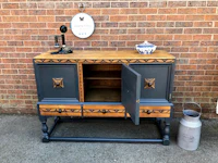 a wooden sideboard with a wooden door and a milk jug