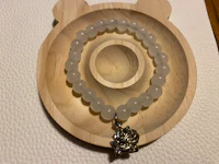 a white beaded bracelet with a teddy bear on it