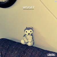 a stuffed animal is sitting on a couch in front of a clock