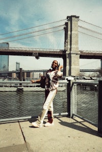 a person standing on a railing near the brooklyn bridge