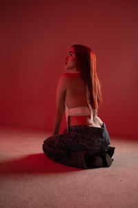 Lilith (Betül), alternatif Türk müziğinin yükselen kadın vokallerinden biri olarak profesyonel stüdyo çekiminde, dizlerinin üzerinde poz verirken güçlü ve duygusal ifadesiyle dikkat çekiyor
