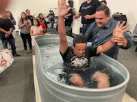 a man is being baptized in a tub