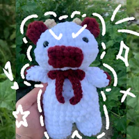 a person is holding a crocheted stuffed animal