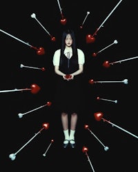 a girl standing in front of a bunch of heart shaped arrows