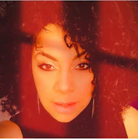 a woman with curly hair is posing for a photo