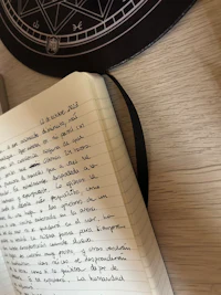 a notebook with writing on it and a tarot card