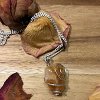 a necklace with a yellow quartz stone and roses