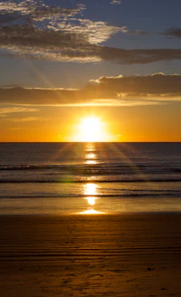 the sun is setting over the ocean