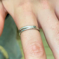 a person's hand with a silver ring on it