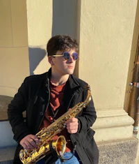 a young man wearing sunglasses and a saxophone