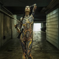 a woman in a body suit holding a gun