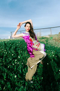 a woman in a pink dress standing in a field