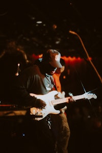 a man playing a guitar in a dark room