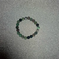 a green and black bracelet on a table