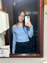 a woman taking a selfie in a bathroom mirror