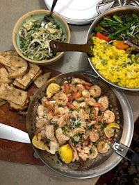 a plate of shrimp, rice, and bread on a table