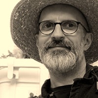 a man wearing glasses and a straw hat