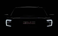 the front end of a gmc truck in the dark