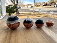 four glass balls sitting on a table next to a street