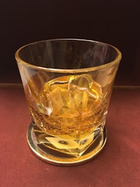 a glass of whiskey with ice in it