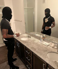 a man in a mask standing in front of a bathroom mirror