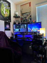 a room with a computer desk and two monitors