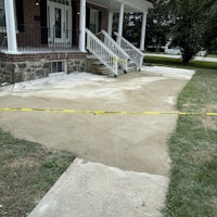 a yellow tape on a sidewalk next to a house