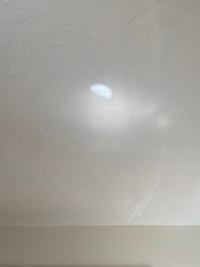 a white ceiling with a light shining on it