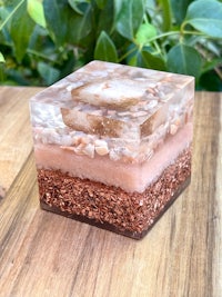 a pink and brown glass cube on a wooden table