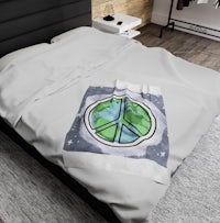 a bed with a blanket that has a peace sign on it