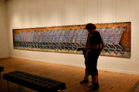 two people looking at a painting in an art gallery