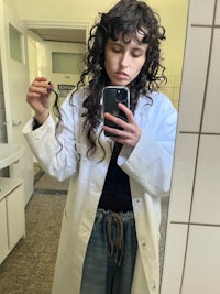 a woman in a lab coat taking a selfie