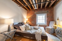 a bedroom with brick walls and a bed
