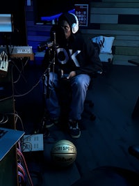 a man sitting in a room with headphones and a basketball