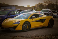 a yellow mclaren sports car parked in a parking lot