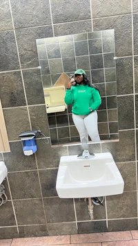 a woman taking a selfie in a public bathroom