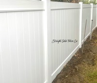 a white vinyl fence in a backyard
