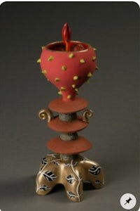 a red vase with a red flower on top