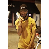 a man holding a gold coin in front of a bike