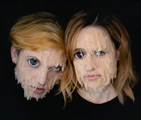 two people with their faces covered in icing