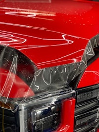 the hood of a red truck is covered in plastic