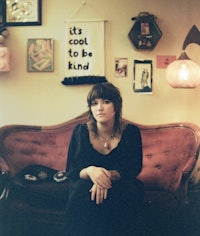 a woman sitting on a red couch in a room